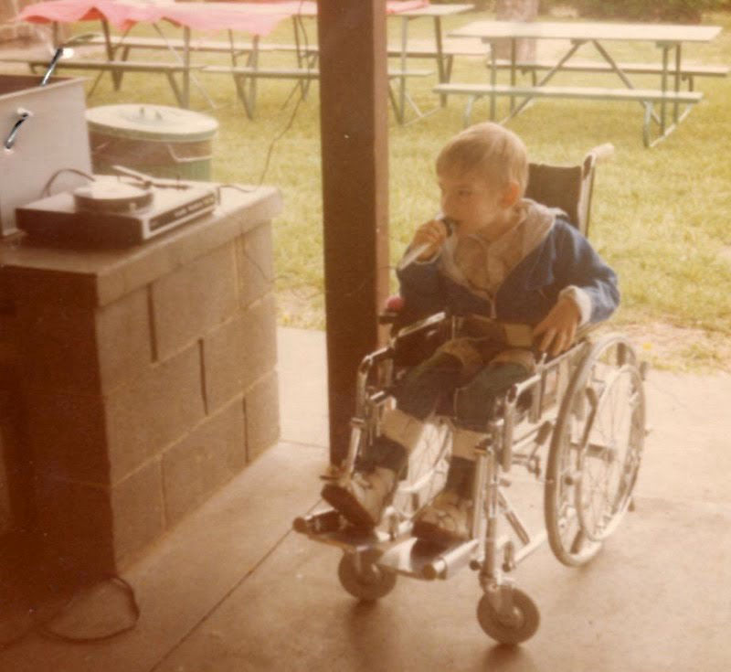 David holding a micriophone at age 7